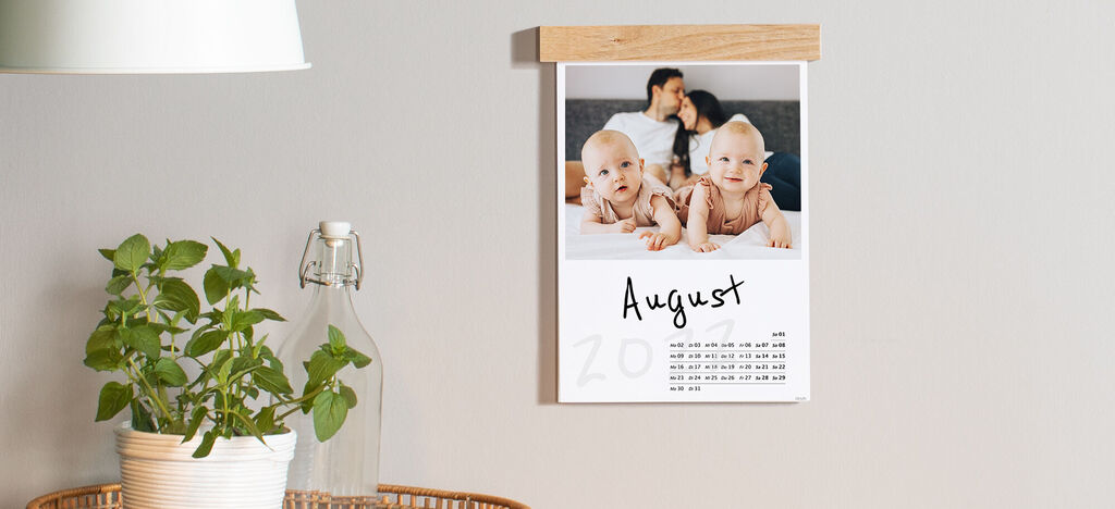 Kalenderblatt für August mit emotionaler Familienszene und Pflanzen im Hintergrund