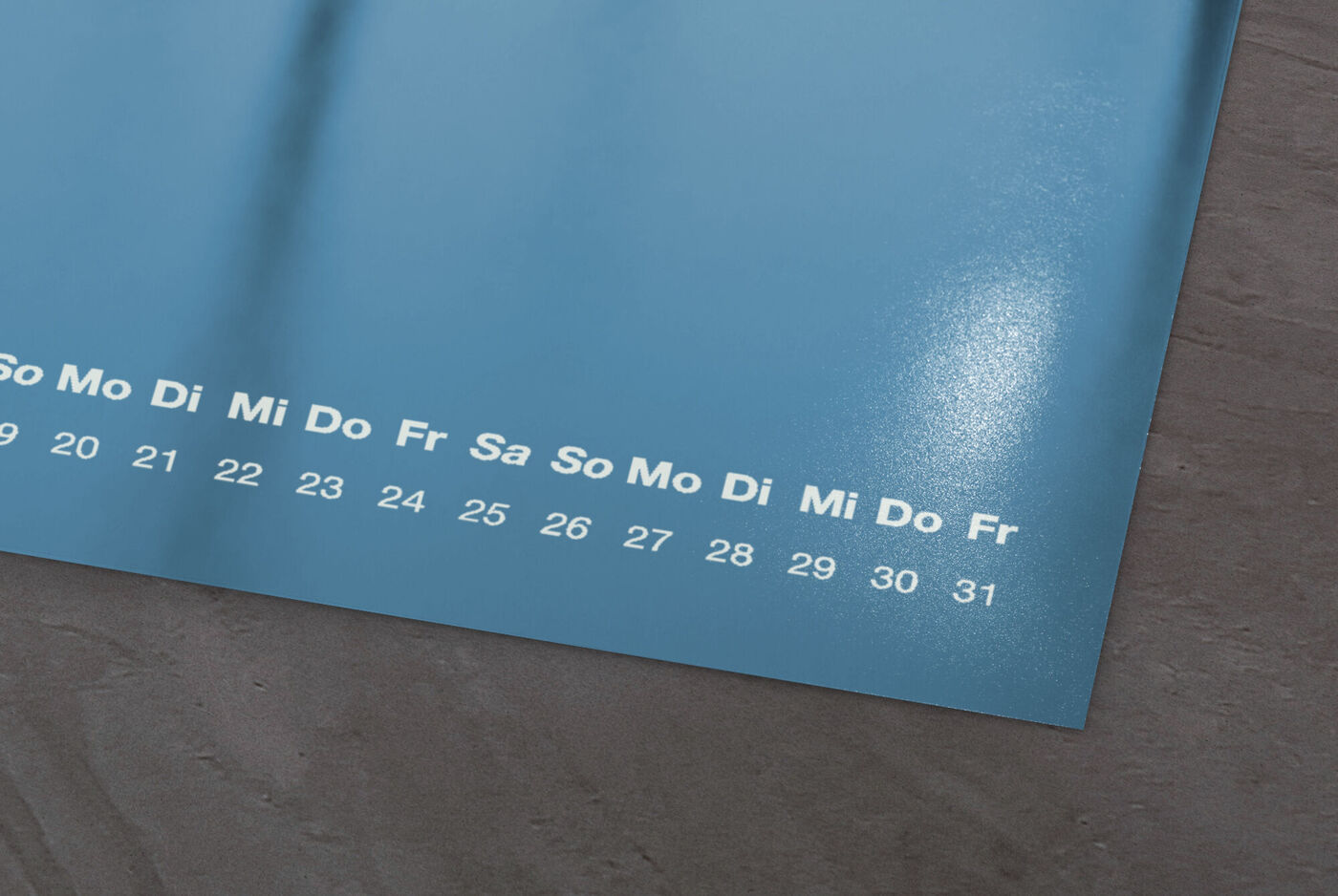 Detailaufnahme eines Kalenders mit Fotopapier in Matt, zeigt Wochentage und Datumszahlen auf einem edlen Hintergrund