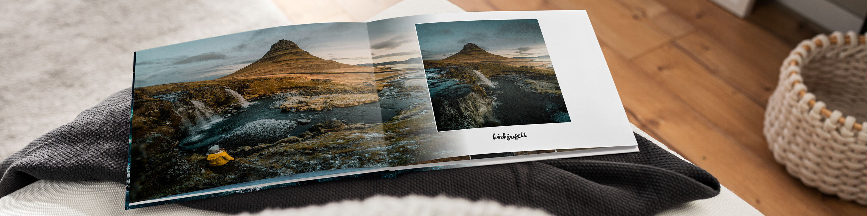 Ein offenes CEWE FOTOBUCH liegt auf einem Tisch und zeigt beeindruckende Landschaftsbilder.