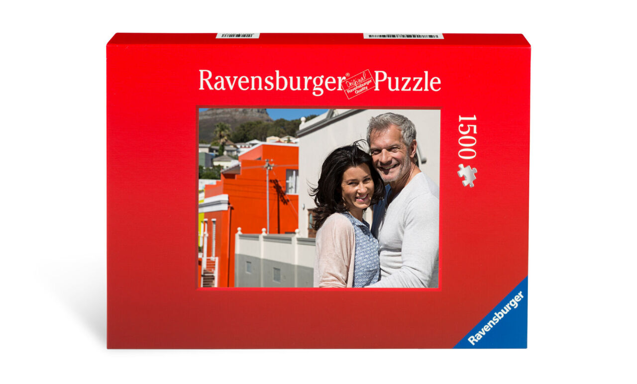 Ein rotes Puzzlebox mit einem Bild von einem Paar vor einer bunten Kulisse.