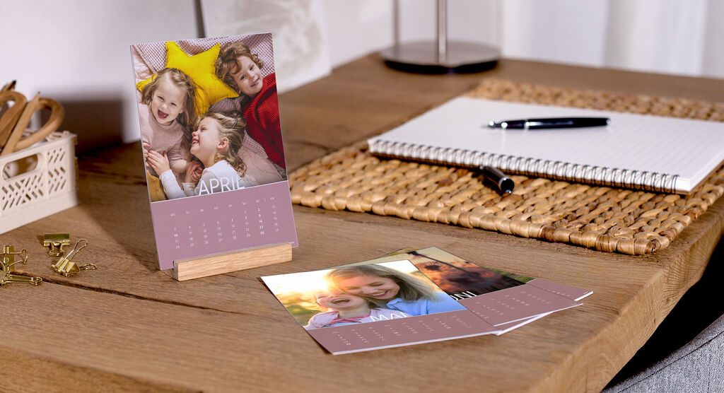 Tisch mit einem Fotokalender für den Monat April, dekoriert mit Fotos und wunderschönen Erinnerungen.