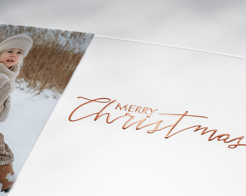 Frohe Weihnachten in schöner Schrift auf einer Karte, umgeben von winterlichen Motiven.