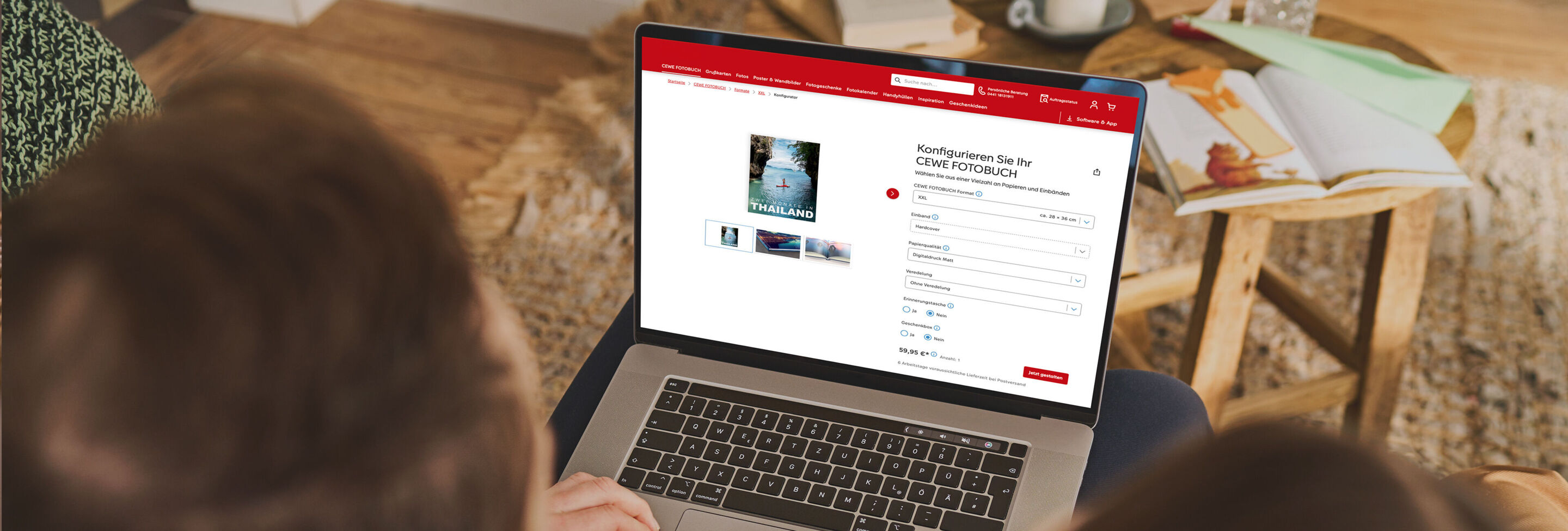 Eine Person sitzt mit einem Laptop auf dem Schoß und konfiguriert online ein CEWE FOTOBUCH.