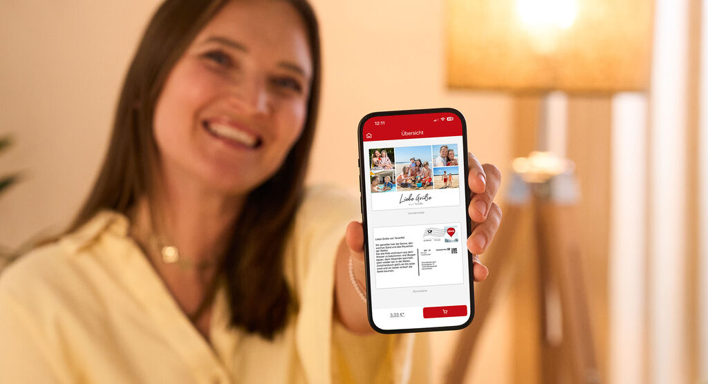 Eine Person schaut auf ein Handy mit einer gestalteten Postkarte
