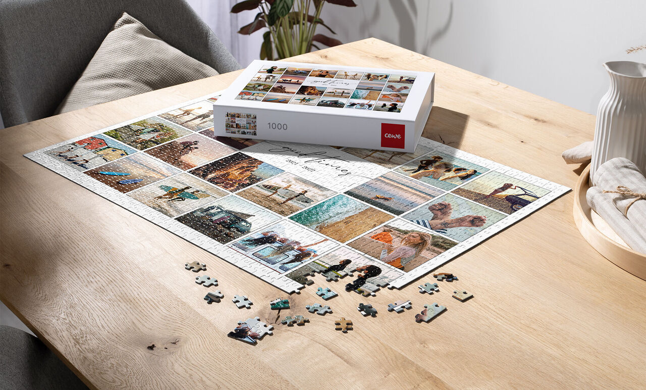 Ein 1000 Teile Puzzle mit vielen Bildern auf einem Holztisch, einige Teile liegen daneben
