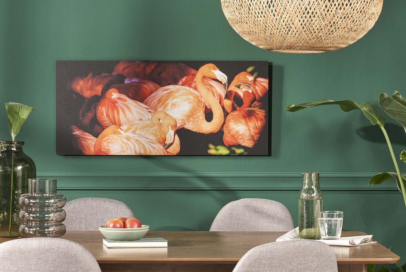 Flamingos in lebendigen Farben auf einer Wand mit grüner Farbe, ergänzt von einem stilvollen Tisch und Stühlen