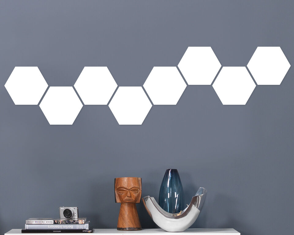 Stilvolle Wanddekoration mit weißen Sechsecken auf grauem Hintergrund, ideal für kreatives Wohndesign