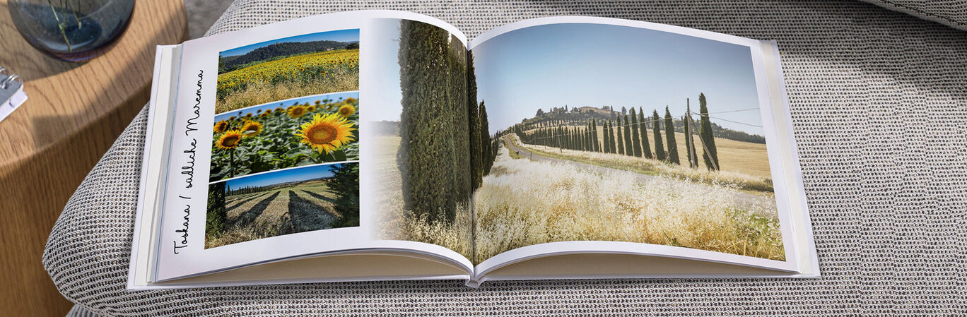 Offenes Fotobuch zeigt schöne Urlaubsfotos von Sonnenblumen und Landschaften