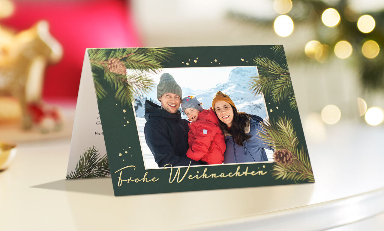 CEWE Klappkarte mit Familienfoto im Schnee, grünem Tannenzweig-Rahmen und der Aufschrift Frohe Weihnachten