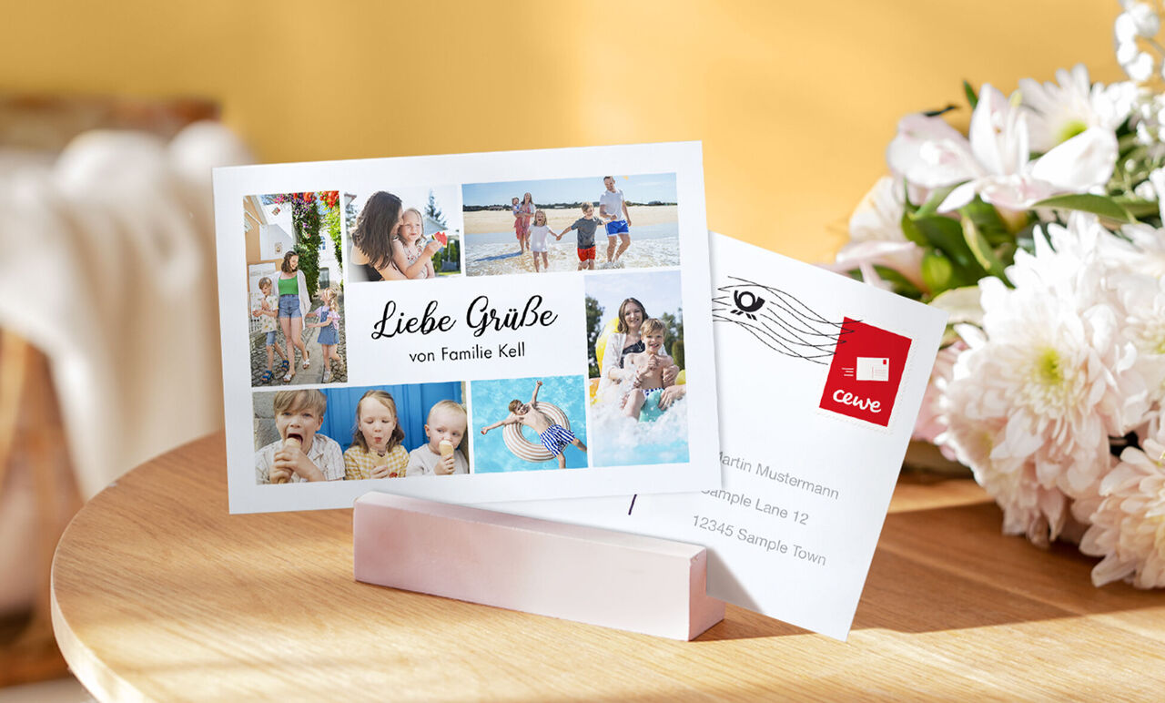 Die liebevoll gestaltete CEWE Grußkarte zeigt fröhliche Familienmomente mit bunten Fotos. Sie liegt auf einem holzfarbenen Tisch mit einer stilvollen Inneneinrichtung.