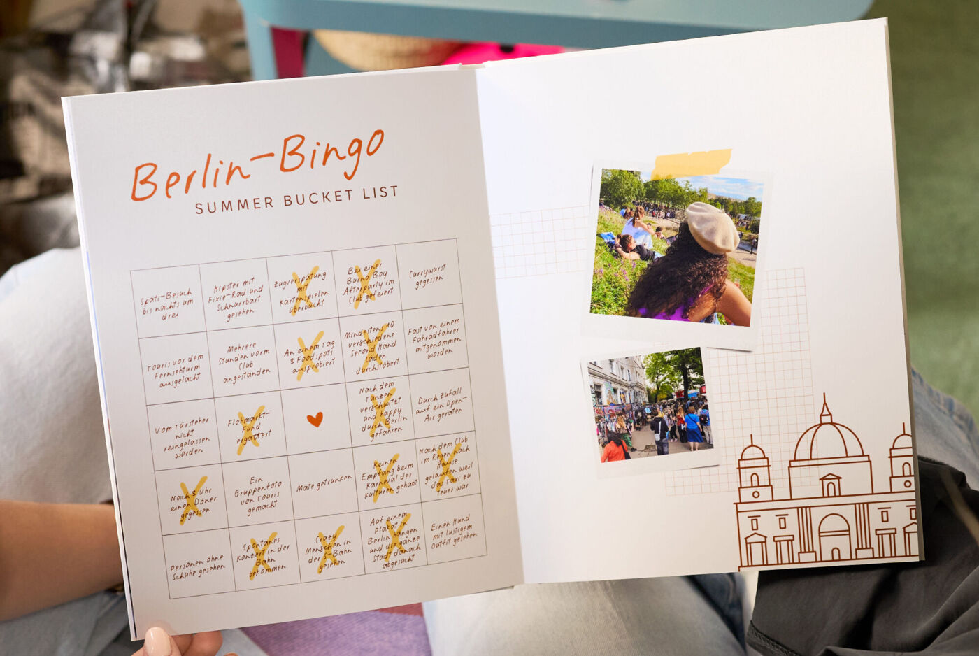 Offenes Fotobuch mit einer „Berlin‑Bingo“-Seite und Fotos von Stadterlebnissen.