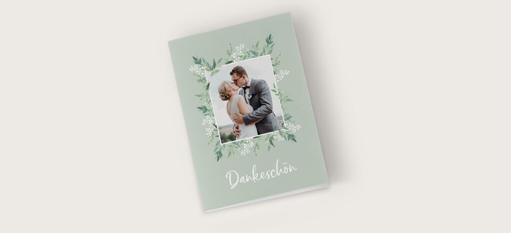 Ein wunderschönes CEWE Fotobuch mit floralem Design und einer liebevollen Hochzeitsaufnahme.