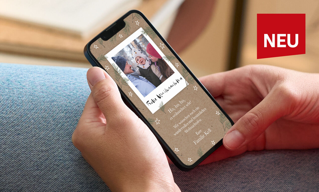 Person hält Smartphone mit CEWE Grußkarte im Weihnachtsdesign und fröhlichem Familienfoto