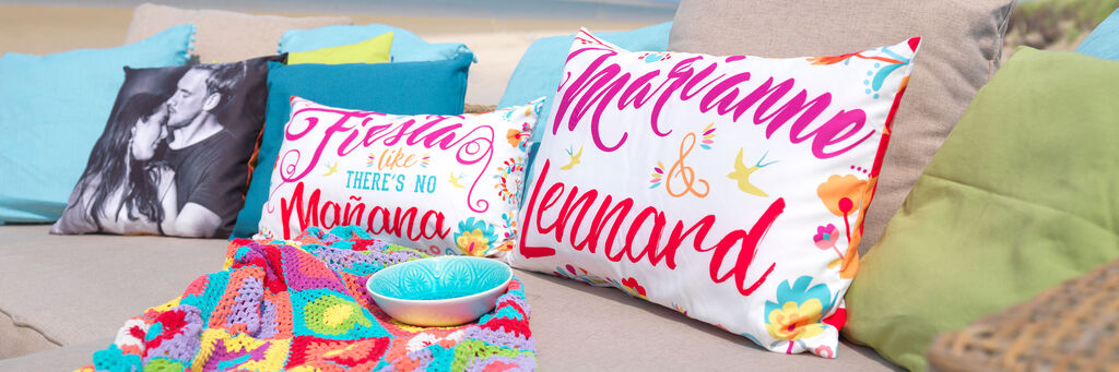 Bunte Kissen mit fröhlichen Sprüchen auf einer Couch