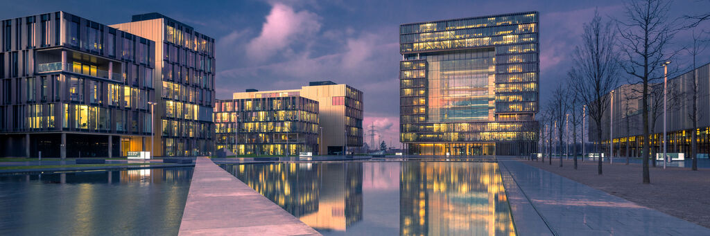 Moderne Gebäude mit leuchtenden Fenstern am Abend