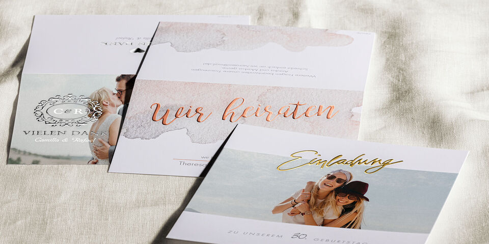 Einladungskarten zur Hochzeit auf einer hellen Stoffoberfläche.