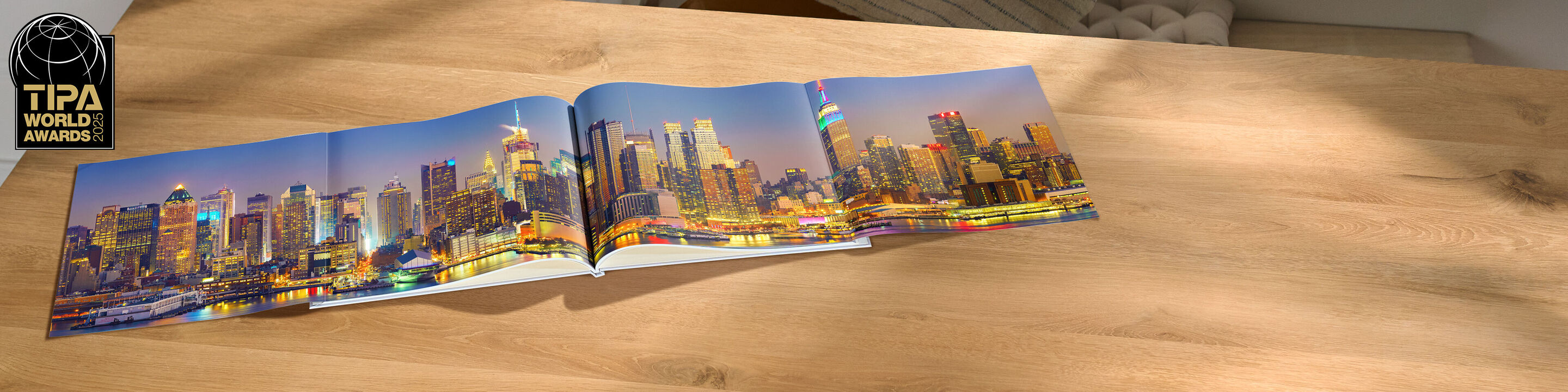 Ein geöffnetes CEWE Fotobuch zeigt eine wunderschöne Skyline von Philadelphia bei Dämmerung auf einem Tisch.