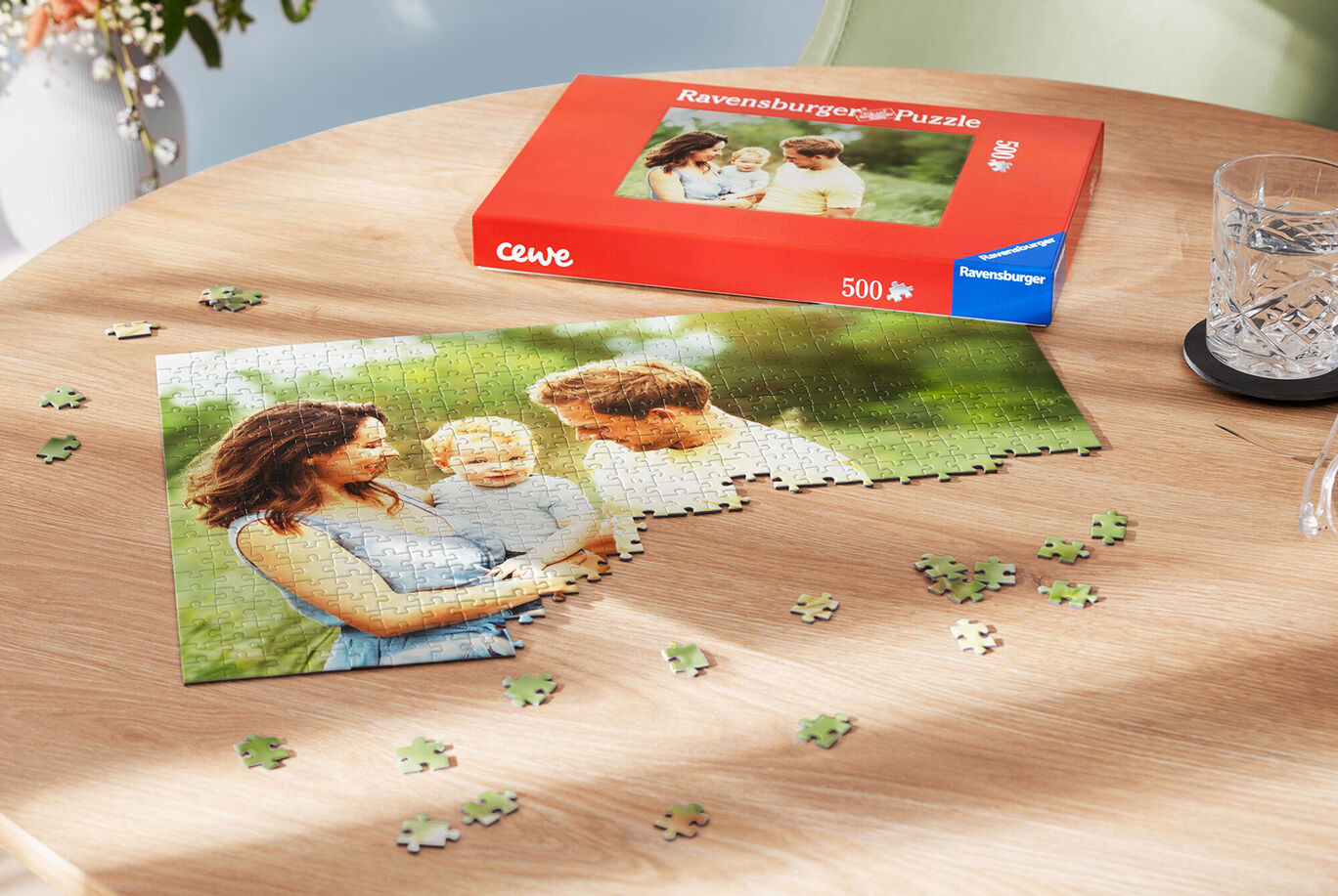 Ein CEWE Puzzle zeigt eine glückliche Familie im Freien. Teile liegen um das Puzzle herum.