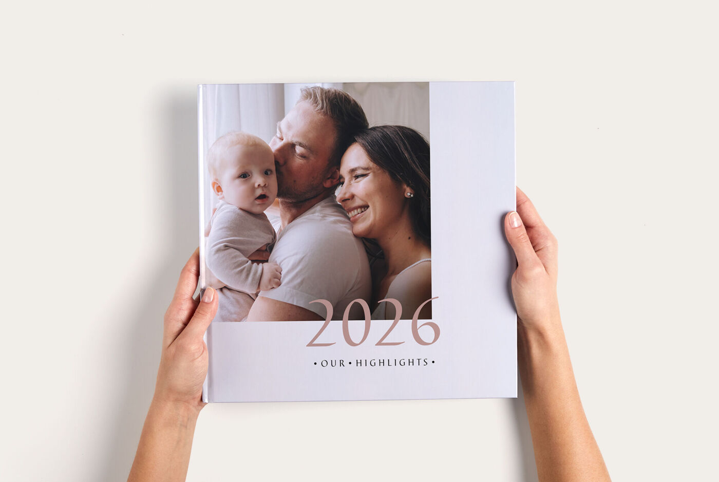 Eine Person hält ein CEWE FOTOBUCH mit dem Titel '2024 - Unsere Höhepunkte' in den Händen, es zeigt frohe Momente.