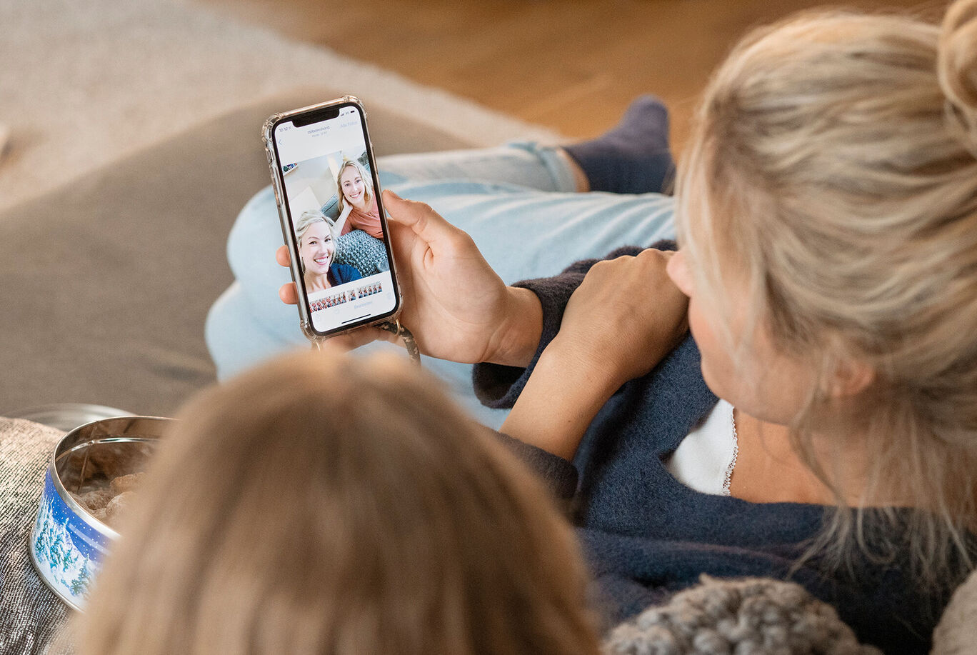 Eine Person schaut glücklich auf ihr Handy.