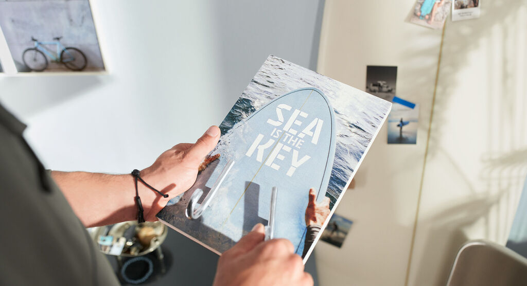 Person hält Fotobuch mit dem Titel 'Sea is the Key' in der Hand