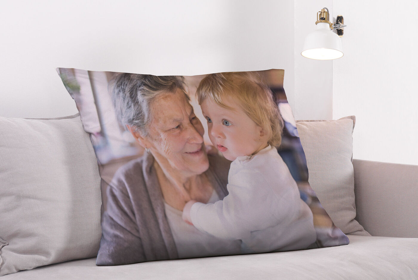 Ein Kissen mit einem liebevollen Familienmotiv, das eine Großmutter mit ihrem Enkelkind zeigt