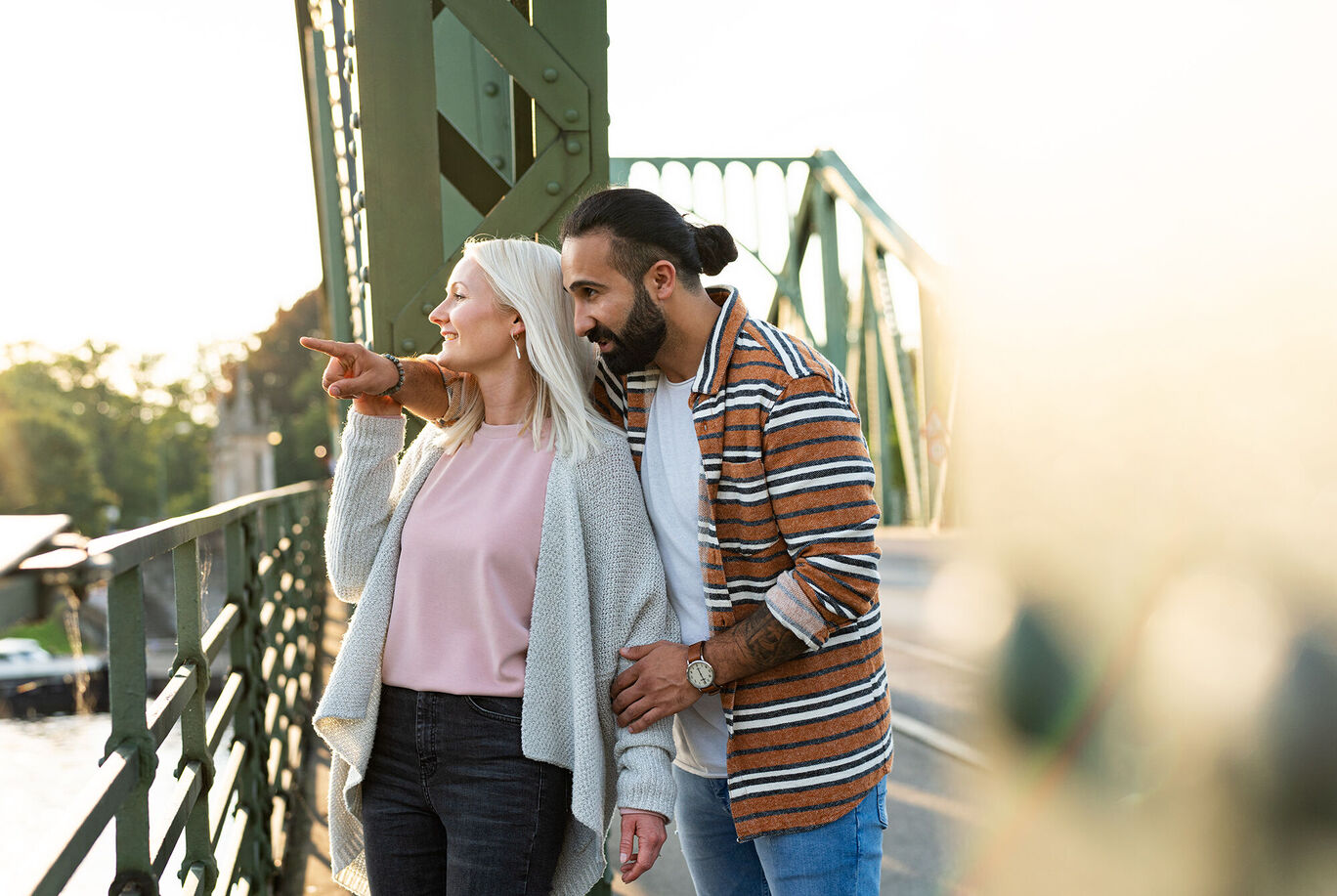 Paar auf einer Brücke zeigt auf etwas in der Ferne
