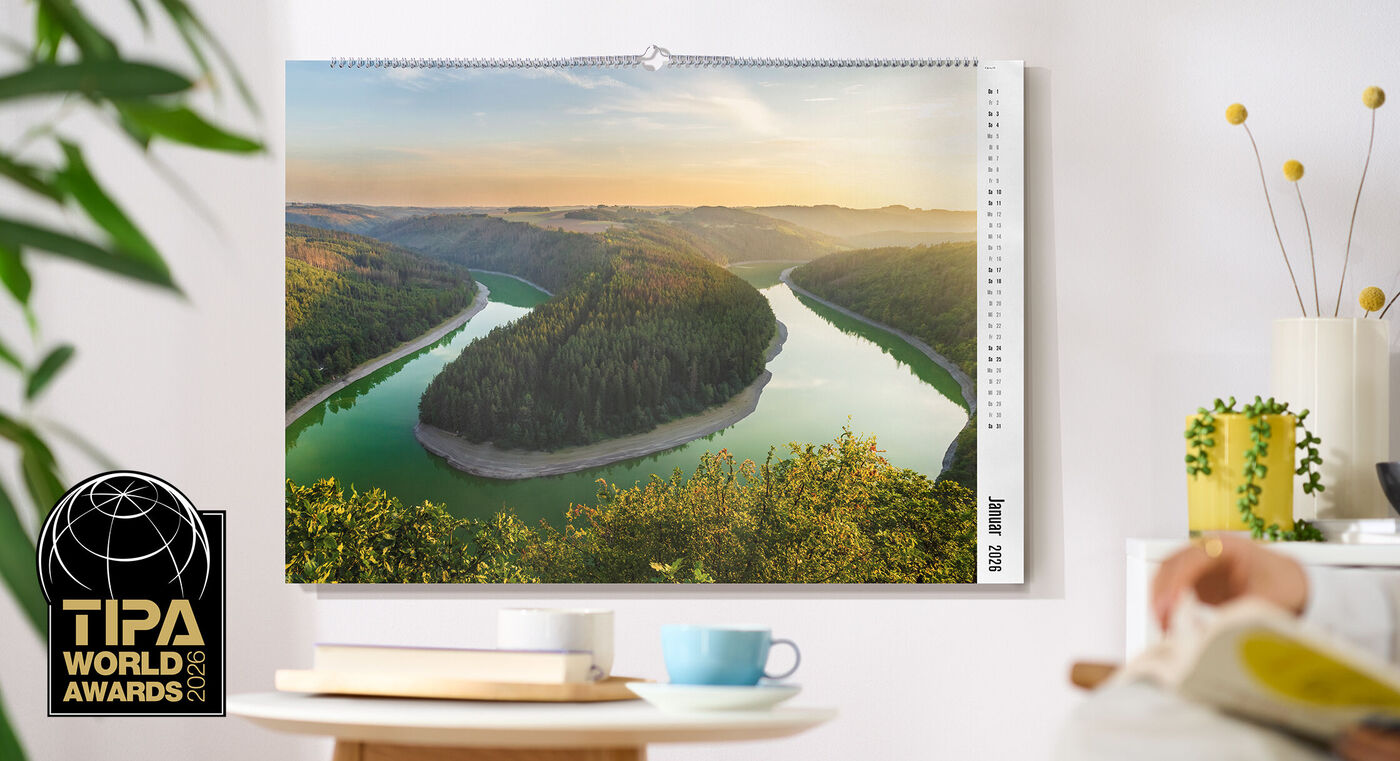 CEWE Fotokalender mit Landschaftsmotiv eines Flusses, der sich durch ein bewaldetes Tal windet, TIPA World Awards Logo links unten