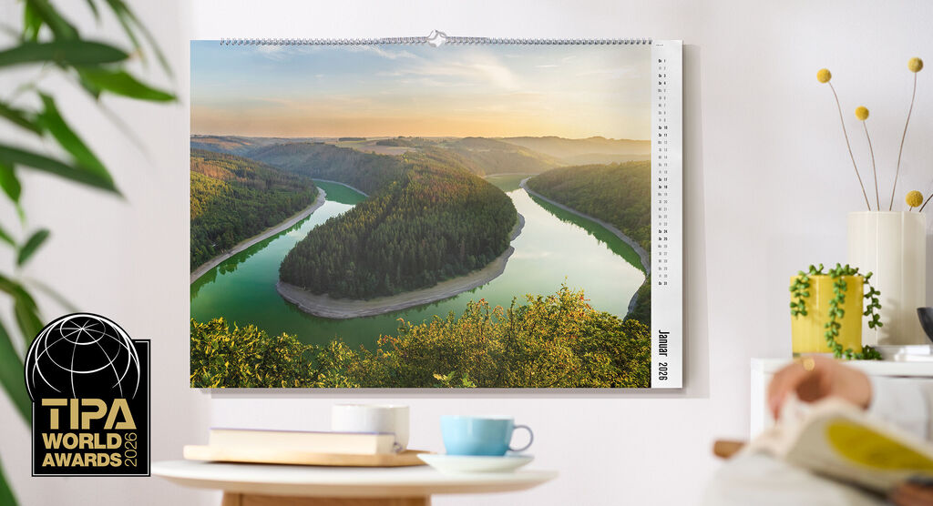 CEWE Fotokalender mit Landschaftsmotiv eines Flusses, der sich durch ein bewaldetes Tal windet, TIPA World Awards Logo links unten