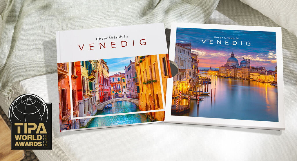 Ein CEWE FOTOBUCH Venedig mit farbenfrohen Stadt- und Kanalansichten neben dem dazugehörigen Schuber