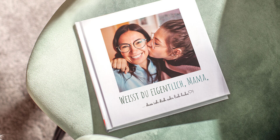 Ein Fotobuch mit liebevollen Erinnerungen auf einem Tisch, ideal für Geschenke
