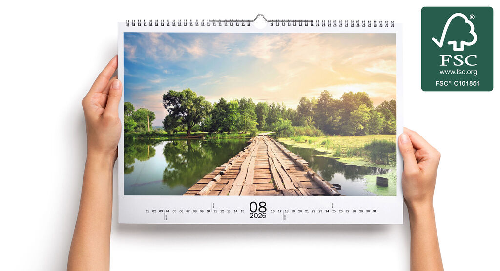 Offener Fotokalender mit einem idyllischen Landschaftsfoto, zeigt einen hölzernen Steg über ein ruhiges Gewässer bei Sonnenschein