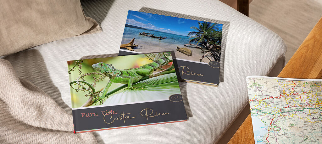 Zwei CEWE Fotobücher, eines mit einem Krokodil auf einem Ast und ein anderes mit einer Küstenlandschaft von Costa Rica.