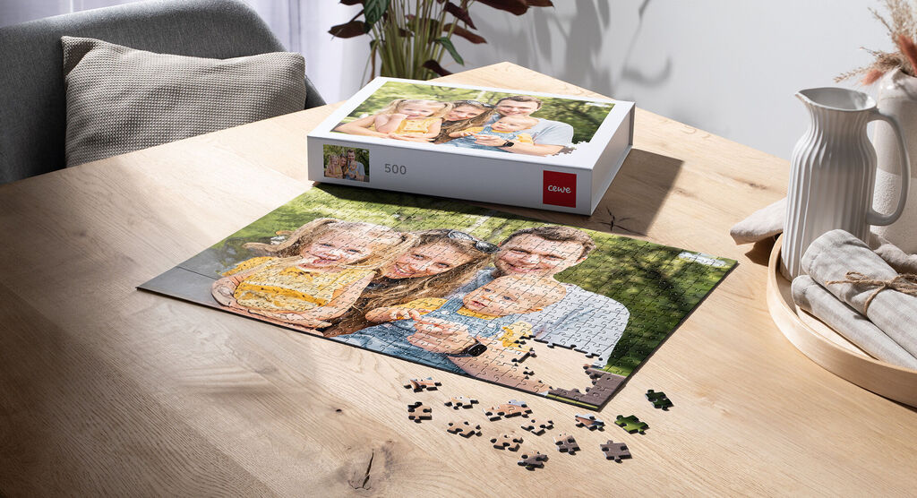 Ein Puzzlestück zeigt eine fröhliche Familie beim Zusammensetzen eines Fotopuzzles auf einem Holztisch.