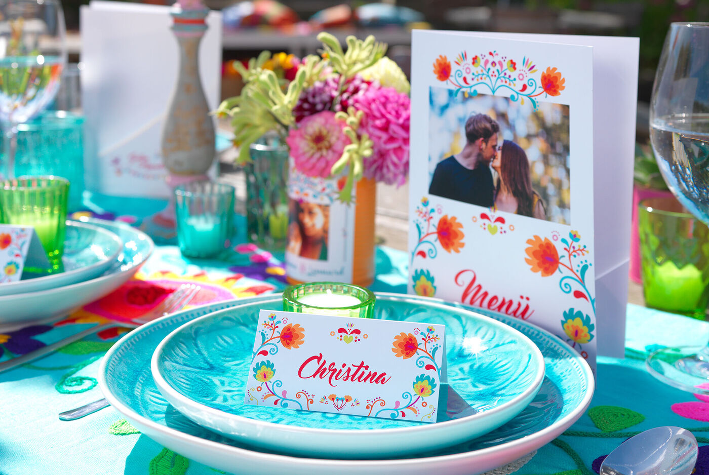 Bunt dekorierter Tisch für ein Festessen mit Menükarten und Blumenarrangement