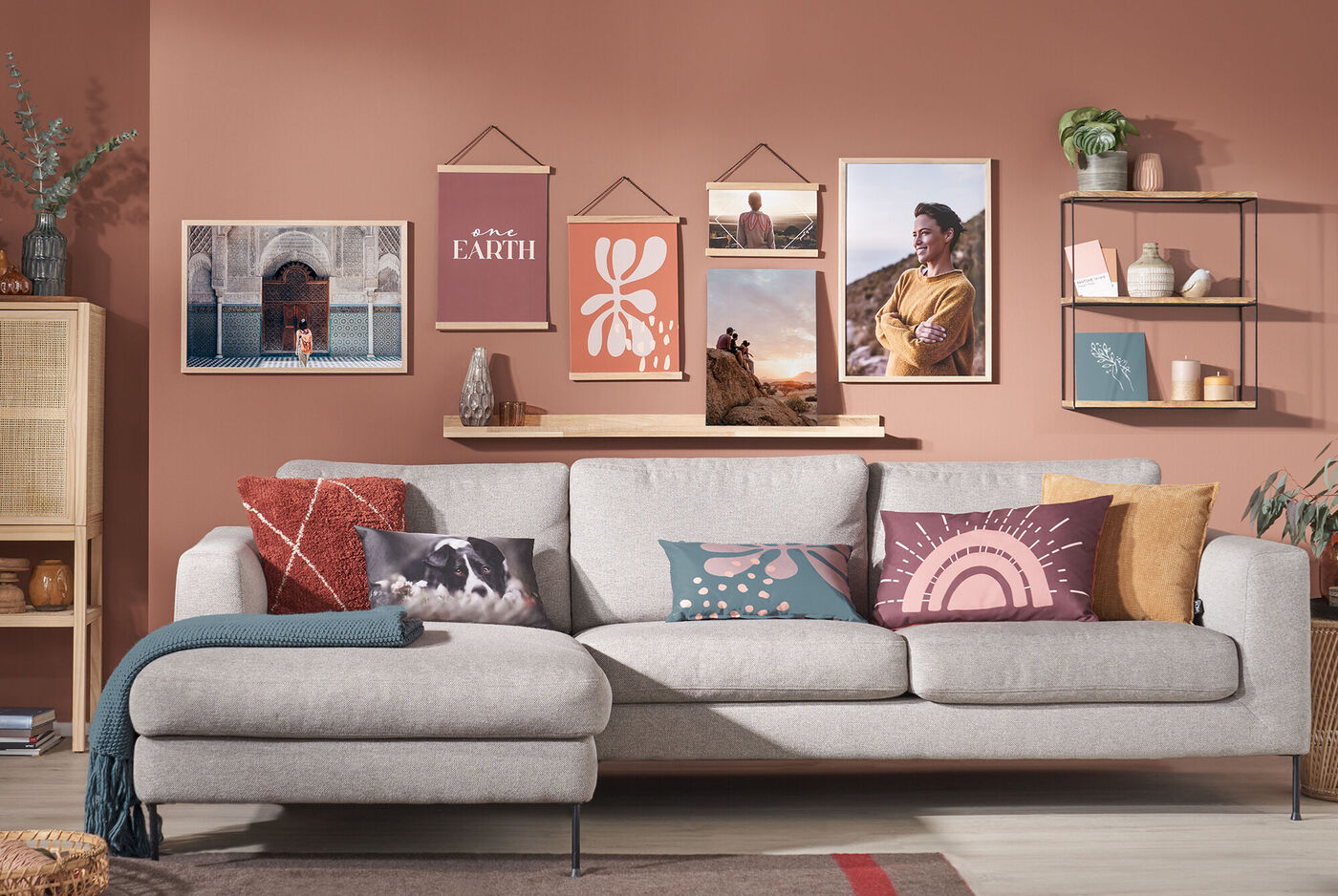 Gemütliches Wohnzimmer mit grauem Sofa und bunten Kissen, dekoriert mit Wandbildern.