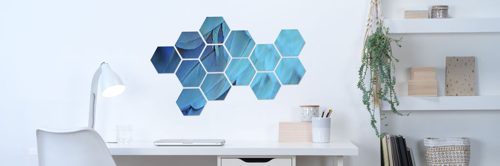 Wandbild mit sechsseitigen Elementen in blauen Farbtönen, die an einer weißen Wand hängen, ideal für kreative Raumgestaltung