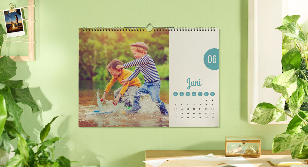 Ein farbenfroher Kalender zeigt zwei Spielende Kinder im Wasser an einem sonnigen Tag. Es ist der Monat Januar.