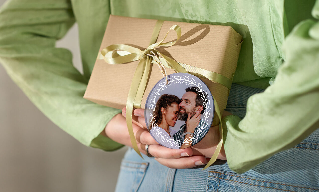 Geschenk mit einer Schleife und einem runden Ornament mit einem Bild.
