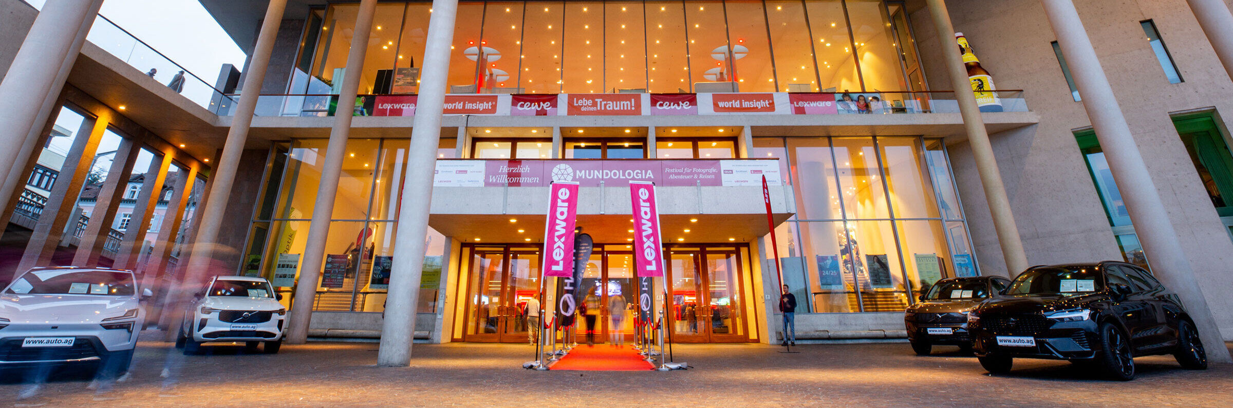 Vor dem Eingang des Konzerthauses Freiburg liegt ein roter Teppich. Mehrere Schilder von Sponsoren sind an der Fassade angebracht.