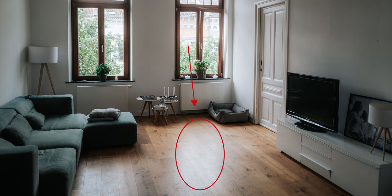 Helle Wohnzimmereinrichtung mit einem komfortablen Sofa, Fernseher und Dekoration.