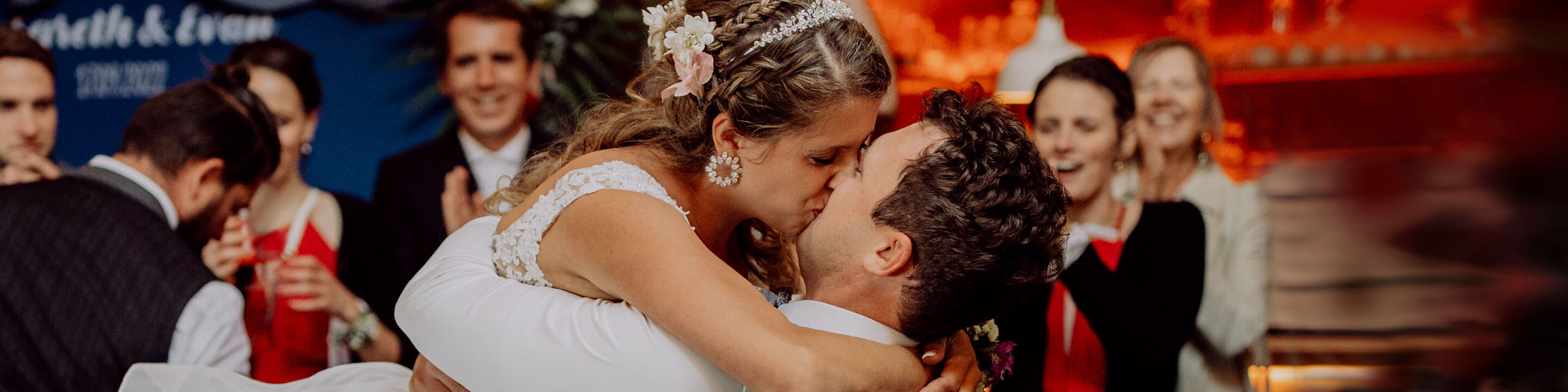 Braut und Bräutigam tanzen glücklich auf ihrer Hochzeit, umgeben von Gästen, die Freude zeigen.