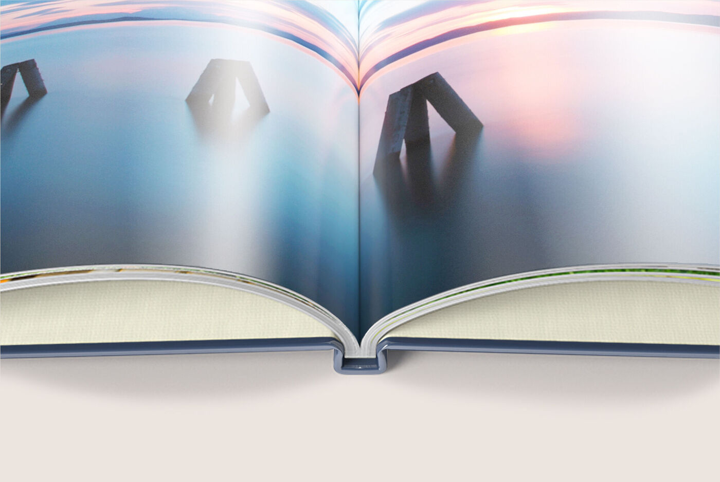 Offenes CEWE Fotobuch mit Landschaftsbildern und einer grünen Nachhaltigkeitsmarke