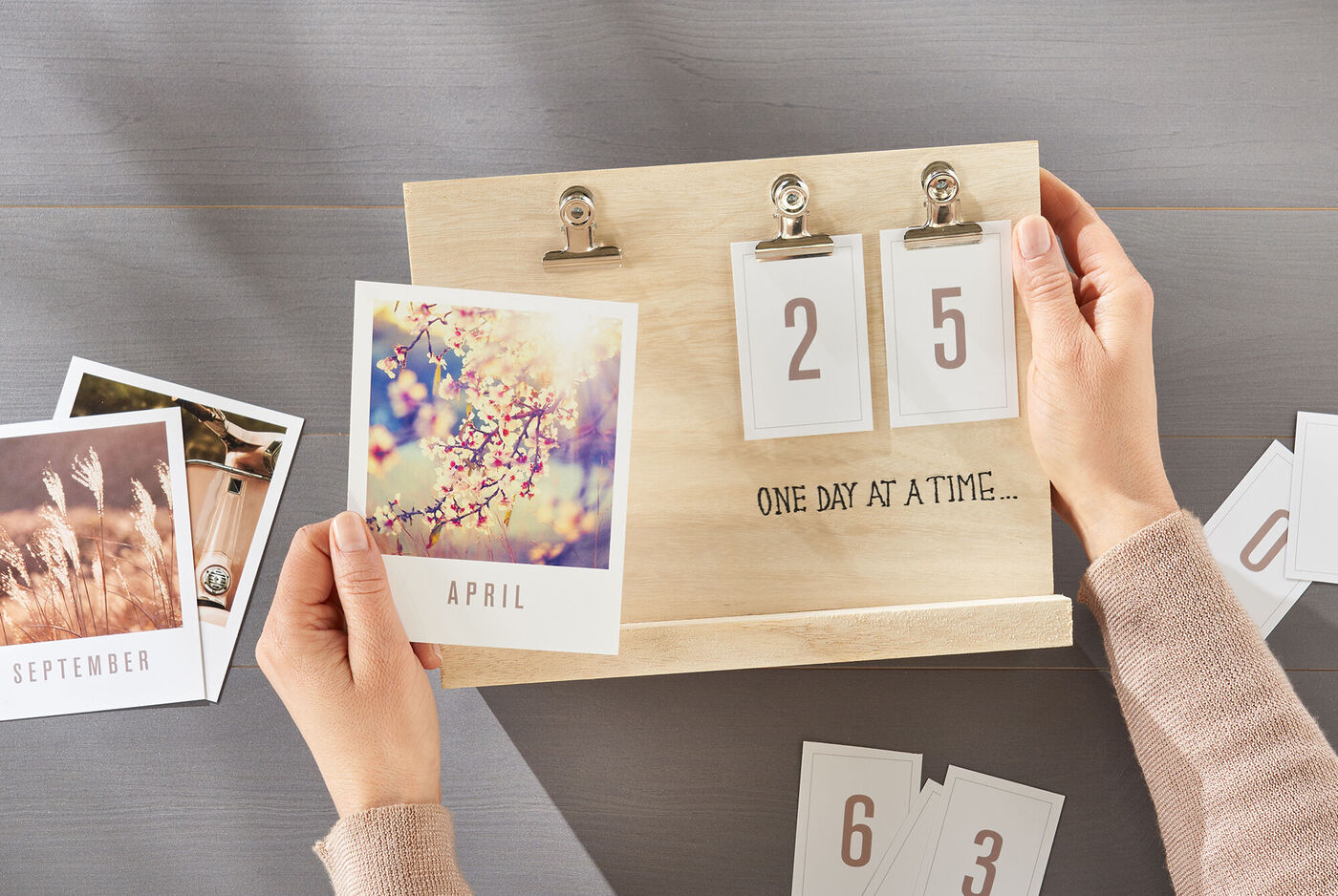 Eine Person hält einen Bastelkalender mit Monatskarten in der Hand, auf dem die Zahl 25 und der Monat April steht
