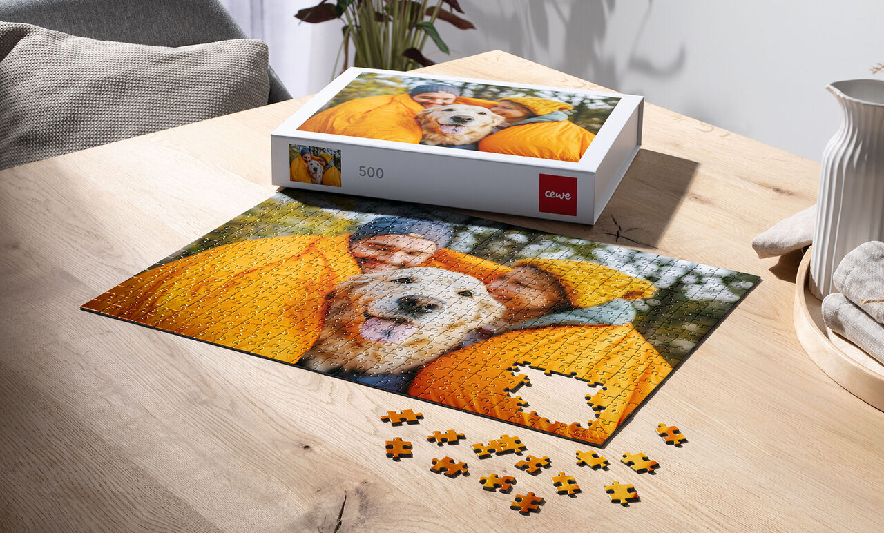 Puzzlespiel mit Bild von glücklicher Familie und Hund in gelben Mänteln
