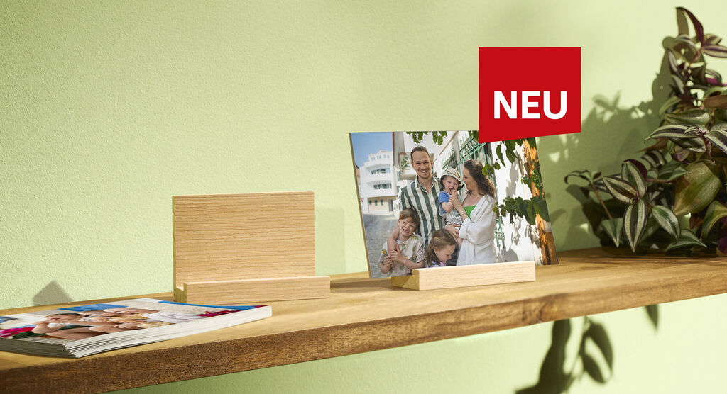 Zwei schöne Bilderrahmen auf einem Holzregal mit Pflanzen und einem Neu-Schild