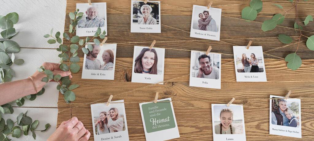 Fotos von glücklichen Menschen an einer Holztafel mit Pflanzenarrangement