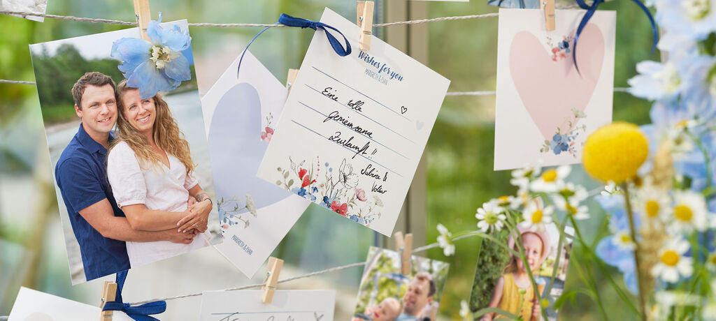 Schöne Grußkarten und Fotos, die an einer Schnur hängen. Bunte Blumen schmücken die Szenarie.