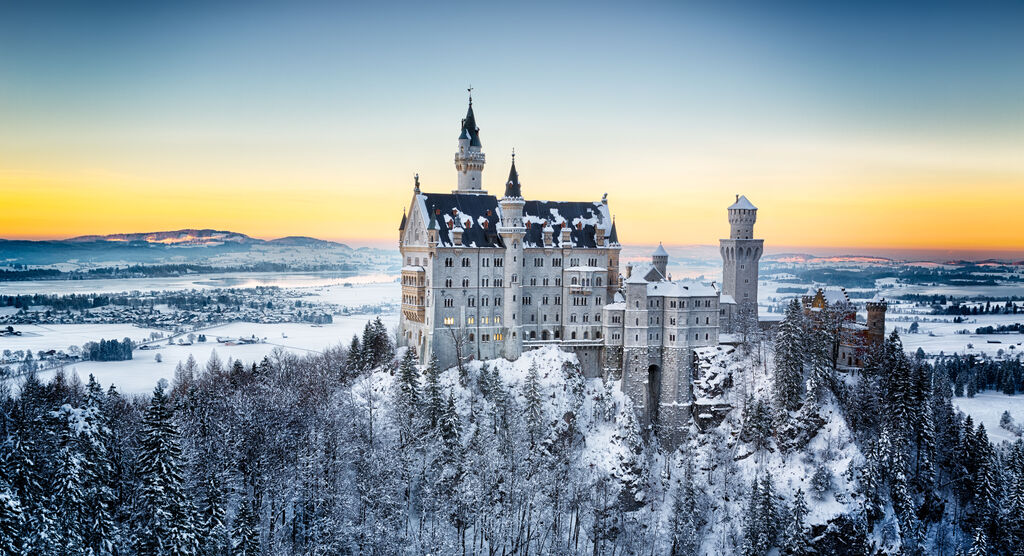 Schneebedecktes Schloss in der Winterlandschaft bei Sonnenaufgang