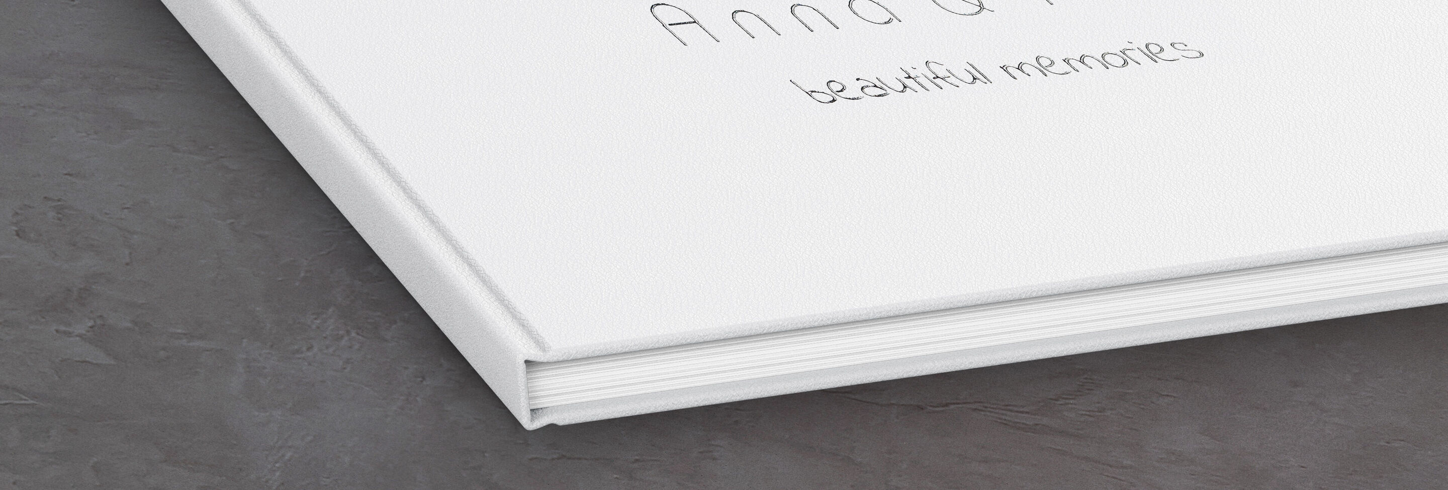 Weißes Fotobuch mit handgeschriebenem Titel "Anna und Peter – schöne Erinnerungen".